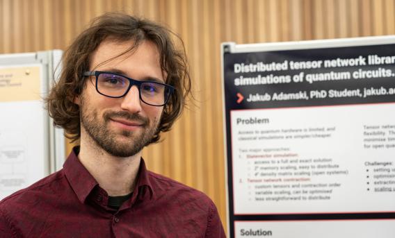Jakub Adamski with poster describing his PhD research