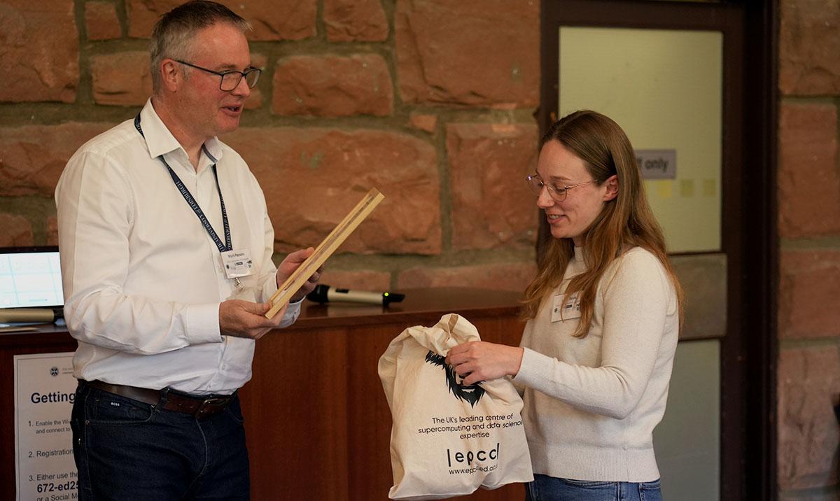 Photo shows female researcher being awarded prize for best poster
