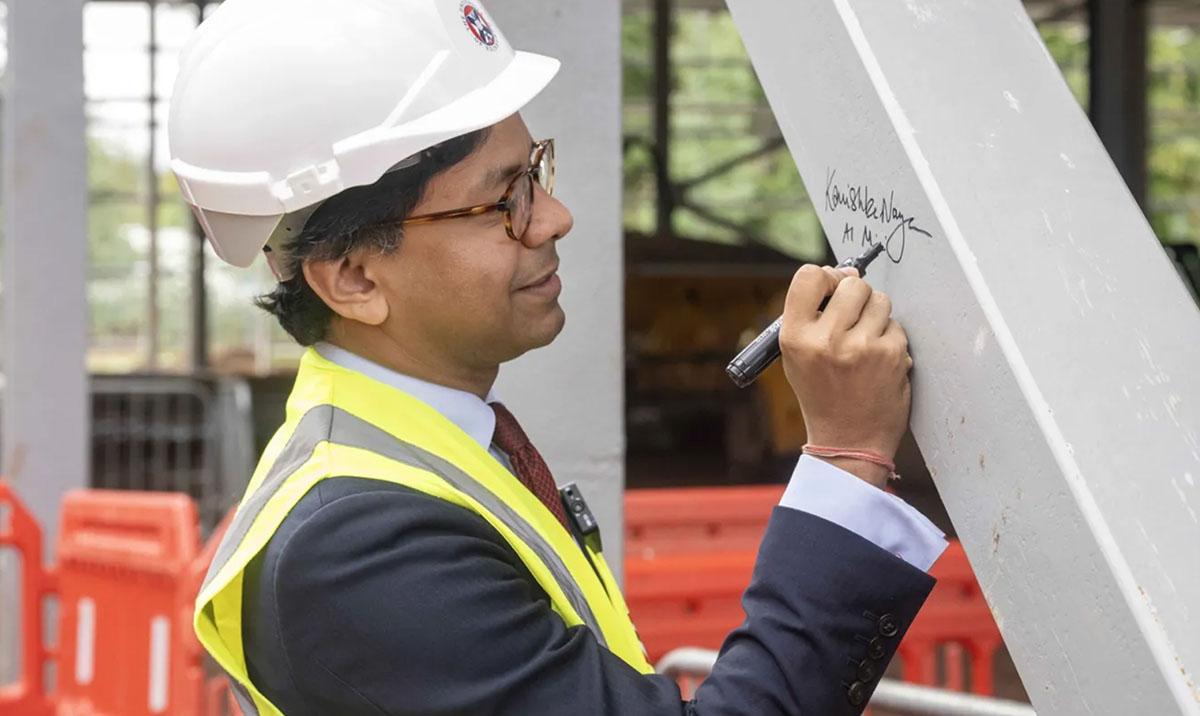 Minister Narayan signs the steel beam