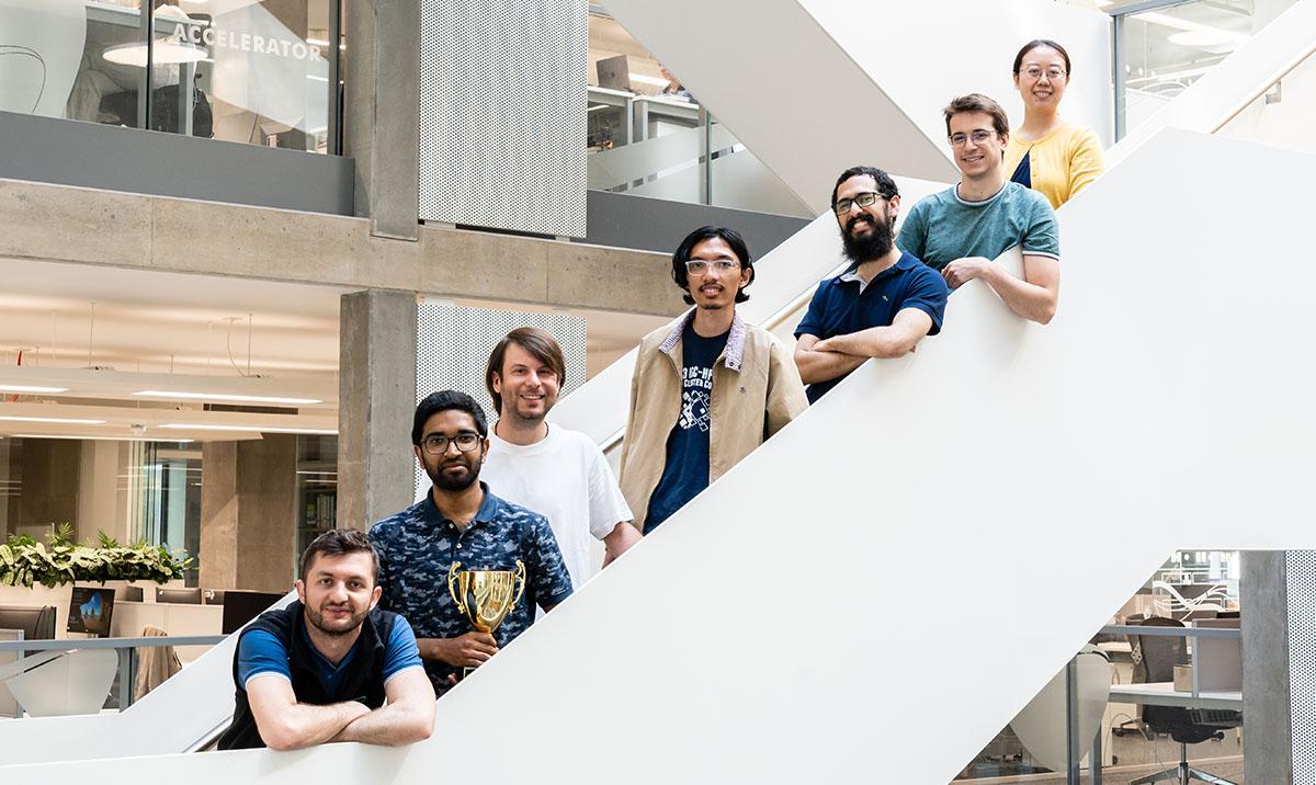 7 people on a white stairway in a modern office building