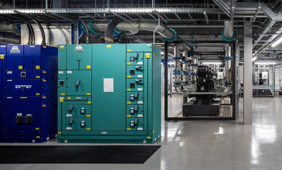 Photo shows interior of computing facility, with control units in green and blue.