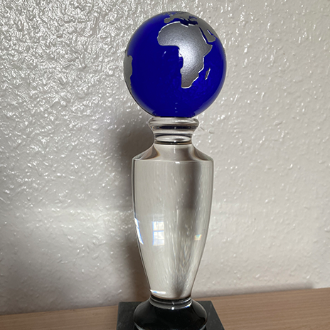 A trophy featuring a globe atop a glass pedestal.