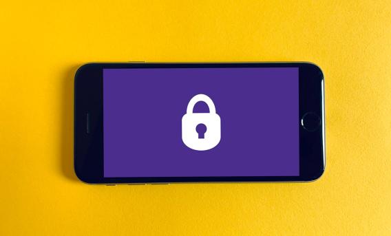 Illustration shows white padlock on purple phone screen against yellow background